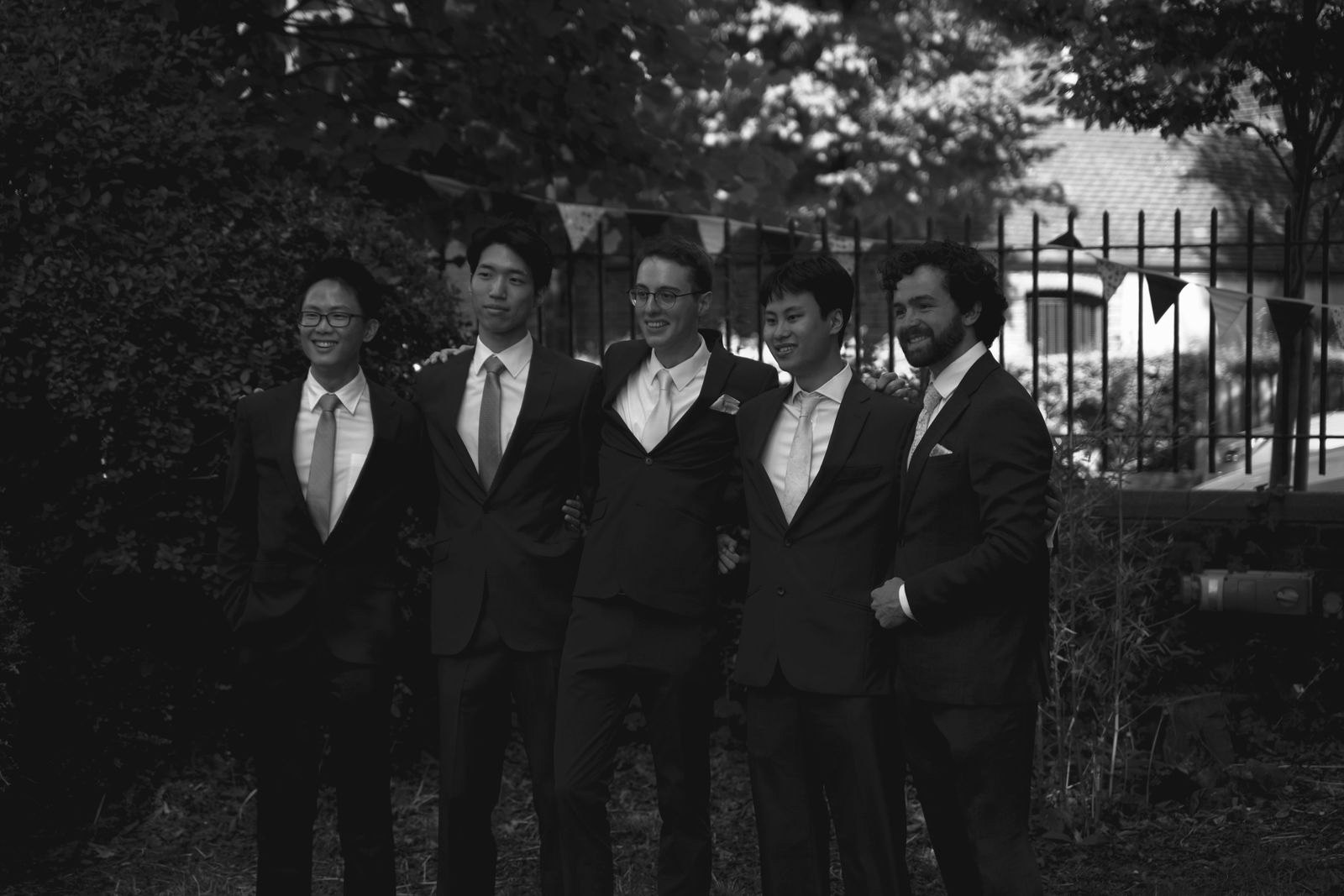 A groom and groomsmen in suits posing together