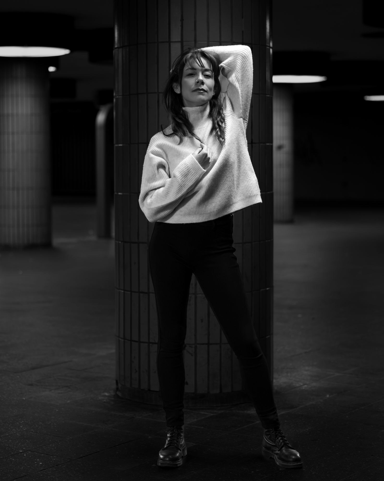 A guest posing in a dimly lit studio