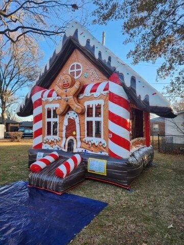 A gingerbread house bounce house with candy-cane trim