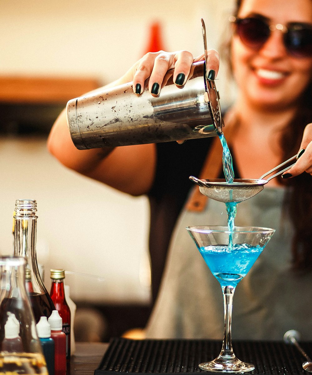 Bartender pouring a blue cocktail