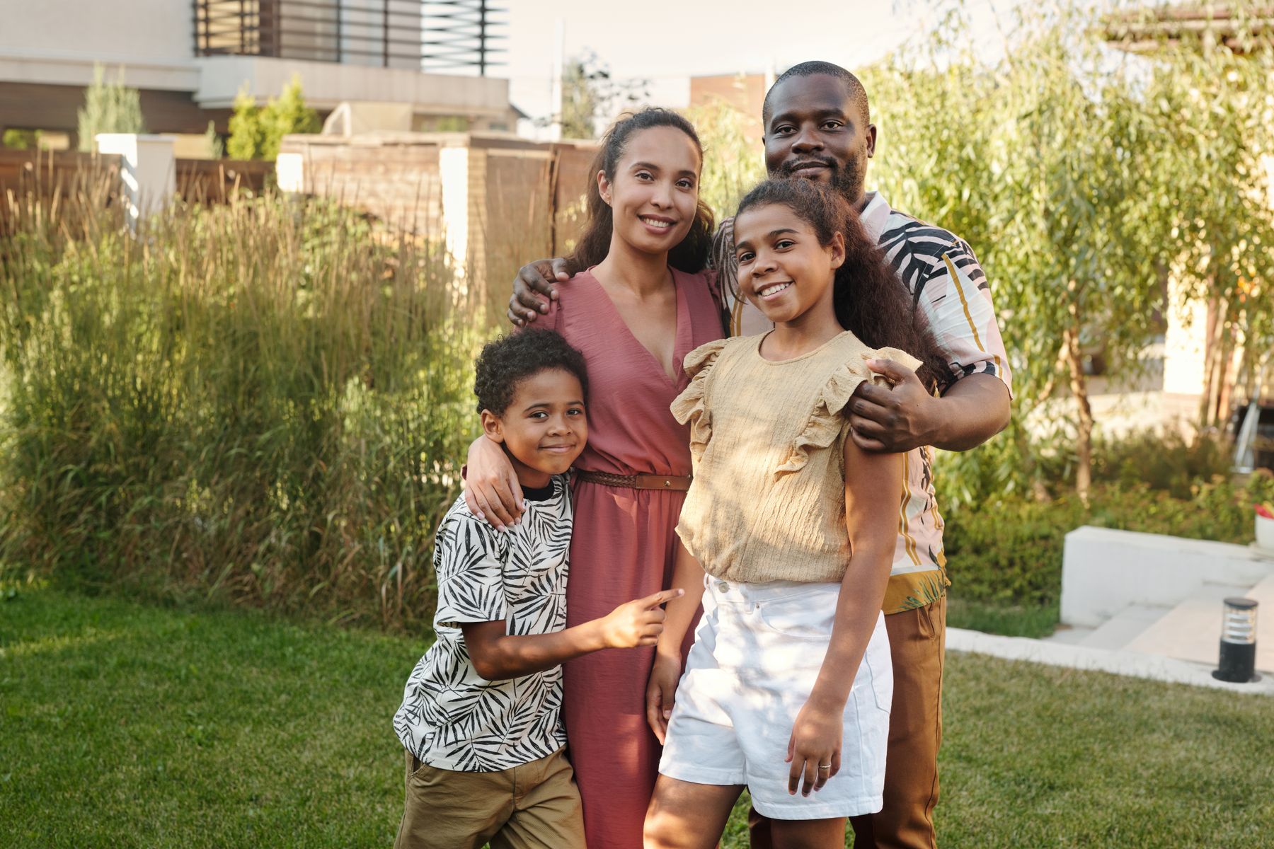 The owners standing together in their backyard with their kids
