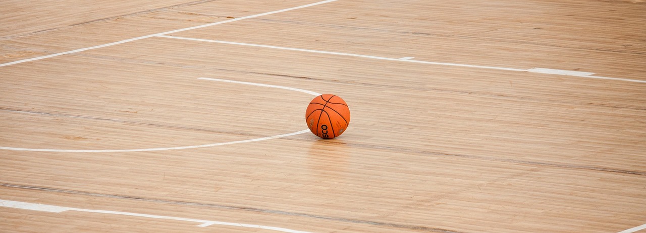 A basketball on a polished gym floor